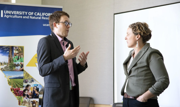 Lenya Quinn-Davidson (right), director of the UC ANR Fire Network, converses with a legislative staffer during an informational session in Sacramento on fire preparedness and home hardening.